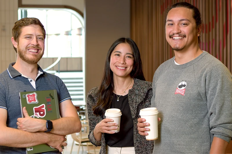 Three Kellanova Employees standing together in the office mobile