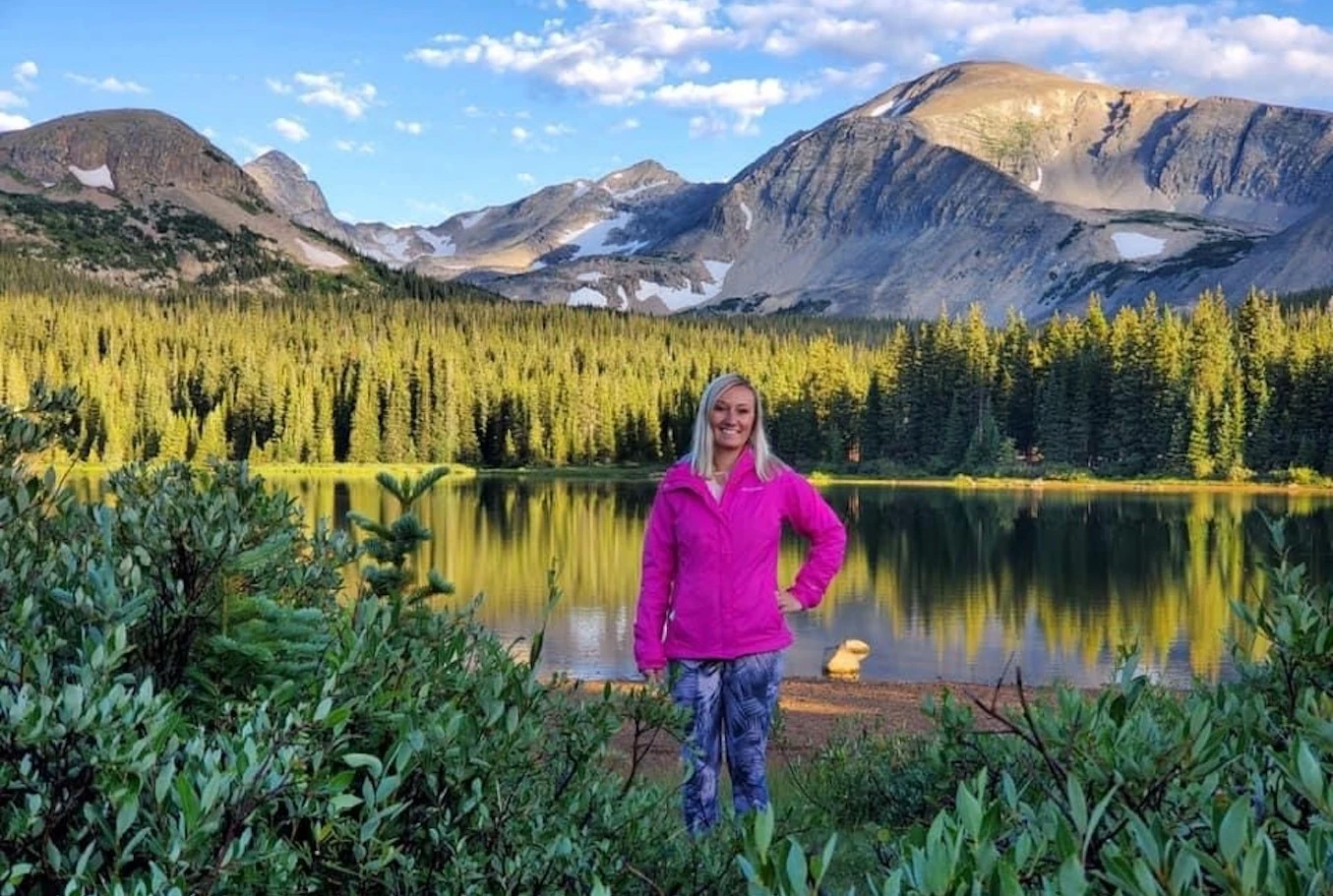 Liz Smith standing in front of a beautiful mountain lake